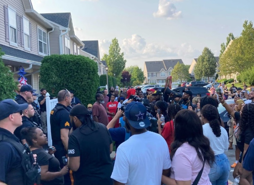 People protesting outside of Edward Cagney Mathews home